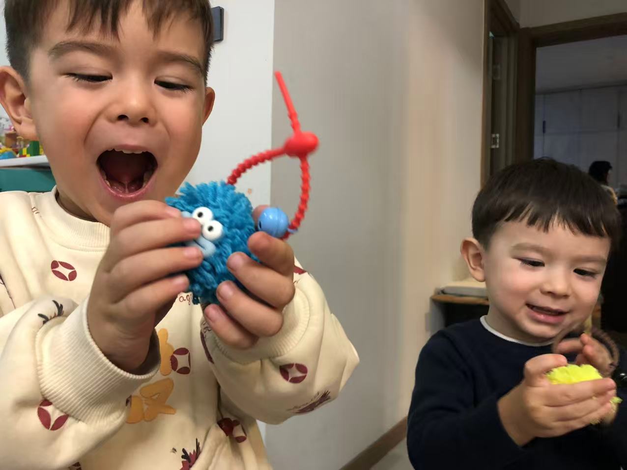 Child holding finished pompom charm